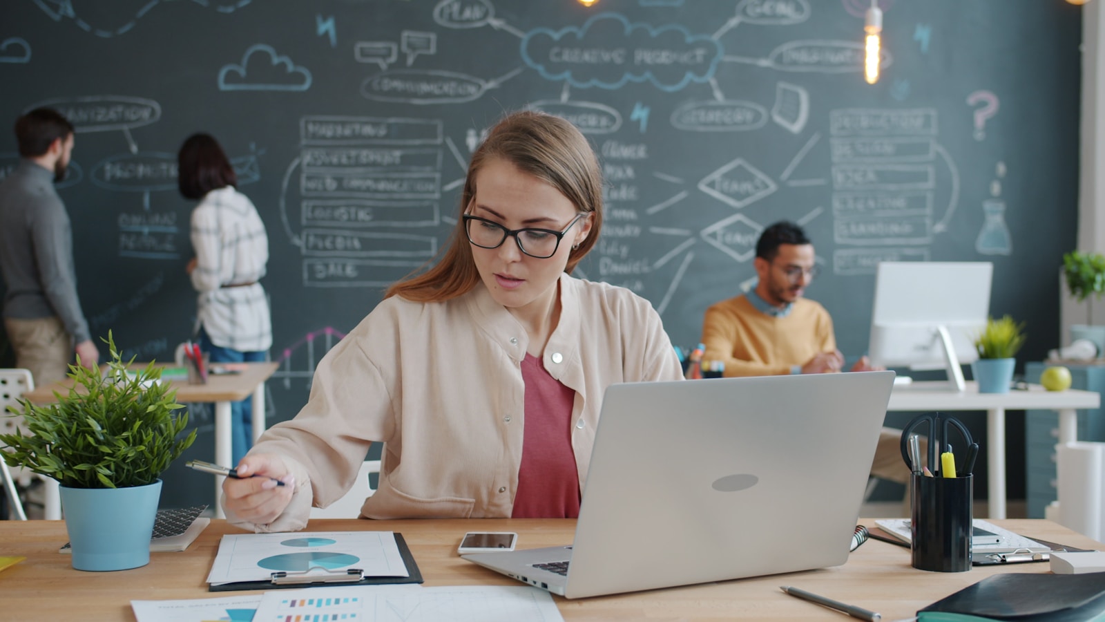 Une dirigeante analyse les graphiques et les chiffres de sa prospection commerciale à son bureau