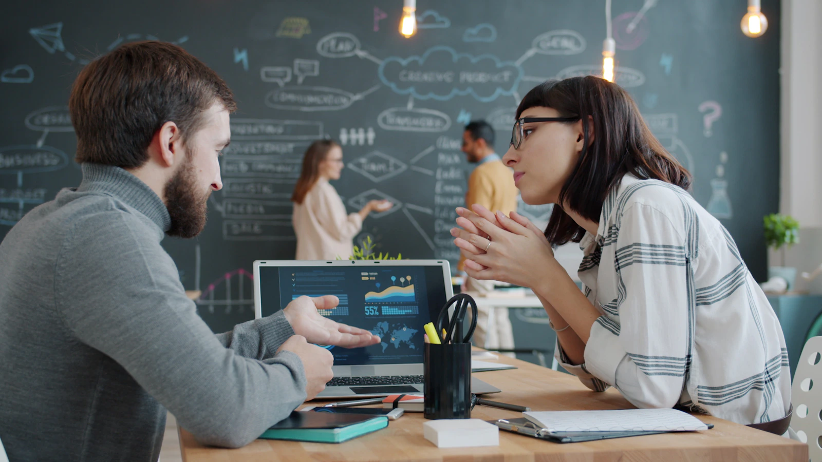 Two professionals reviewing charts on a laptop to validate proprietary-data research