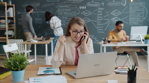 Woman celebrating success while on a business call.