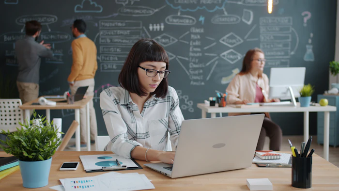 Designer working on a laptop in a collaborative office