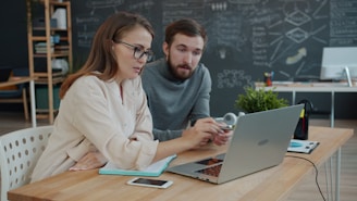 Two colleagues collaborating on a project at a laptop.