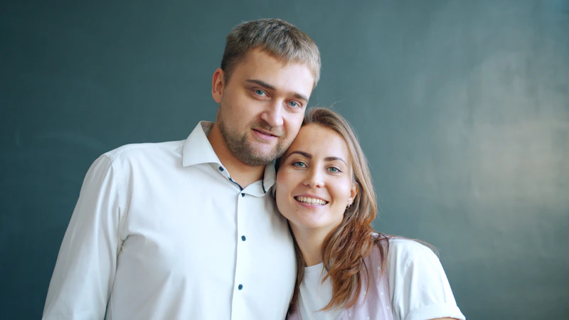 smiling couple against a dark background