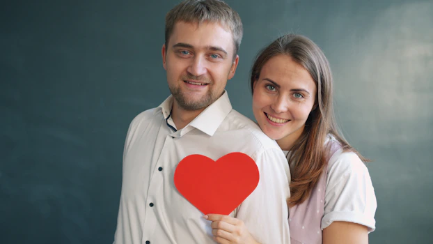 Couple holding a red heart symbol