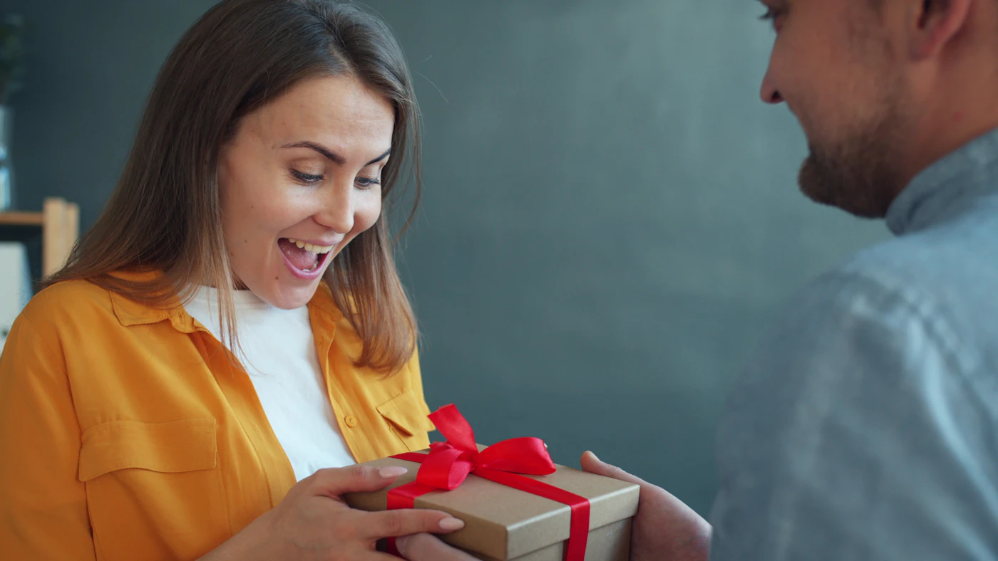 Couple exchanging an anniversary gift at home