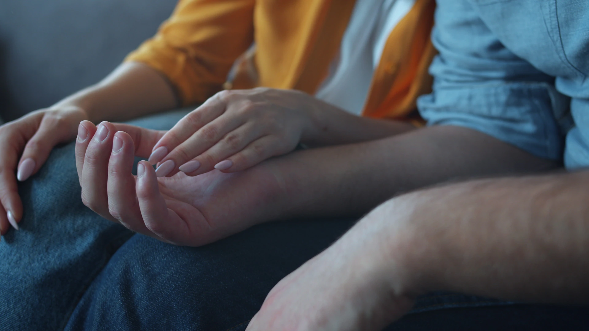 A gentle hand rests on another's palm.
