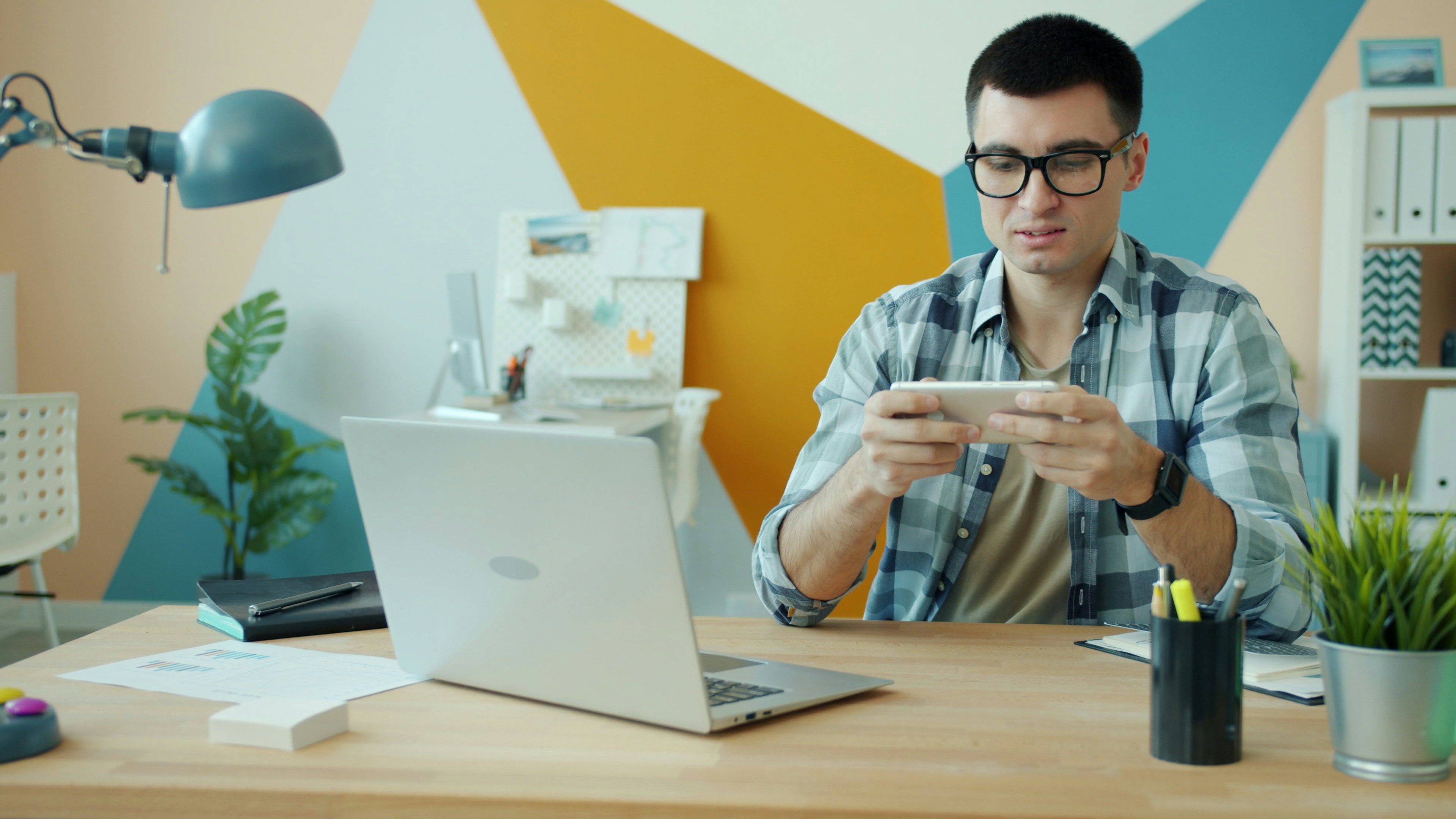 Man playing video game on phone at desk