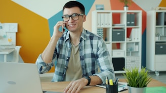 Man in glasses talking on phone at desk