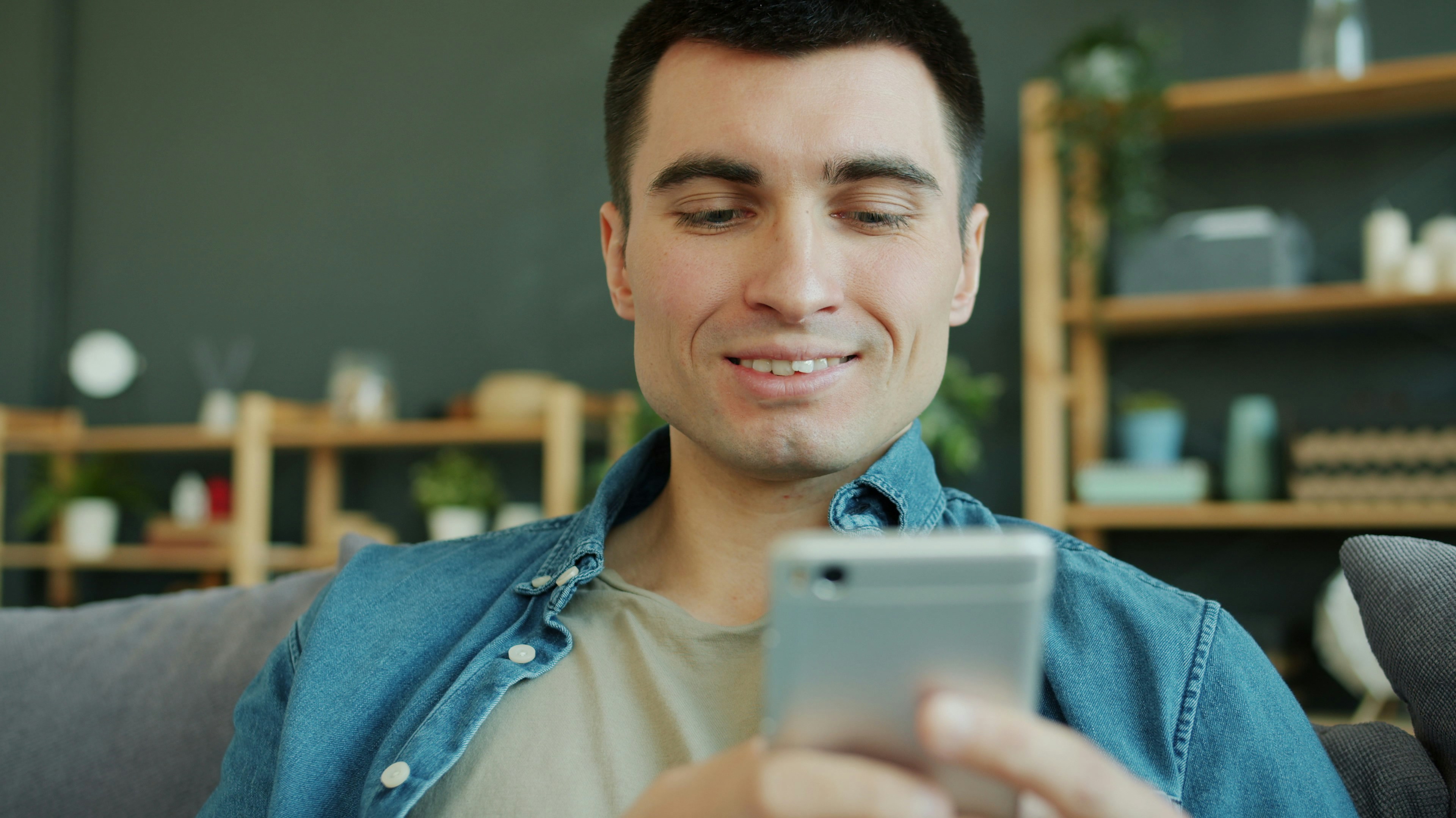 Person smiling while using a dating app on their phone, indicating online connection - poly couples near me