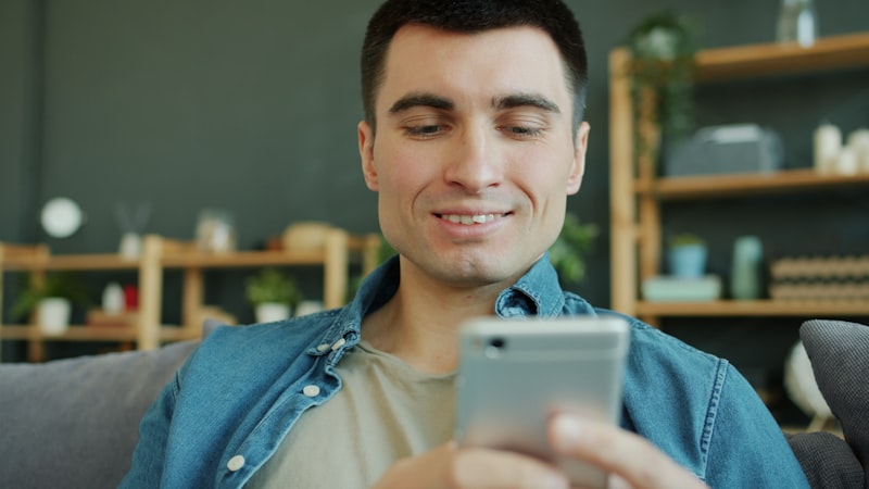 Man smiling at his phone checking lab results
