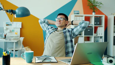 Man relaxing at desk in colorful office