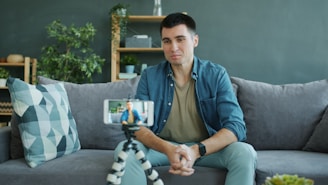 Man sitting on couch recording video on phone