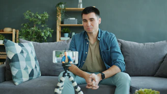 Man sitting on couch recording video on phone