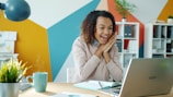 Excited woman looking at laptop with steaming coffee.