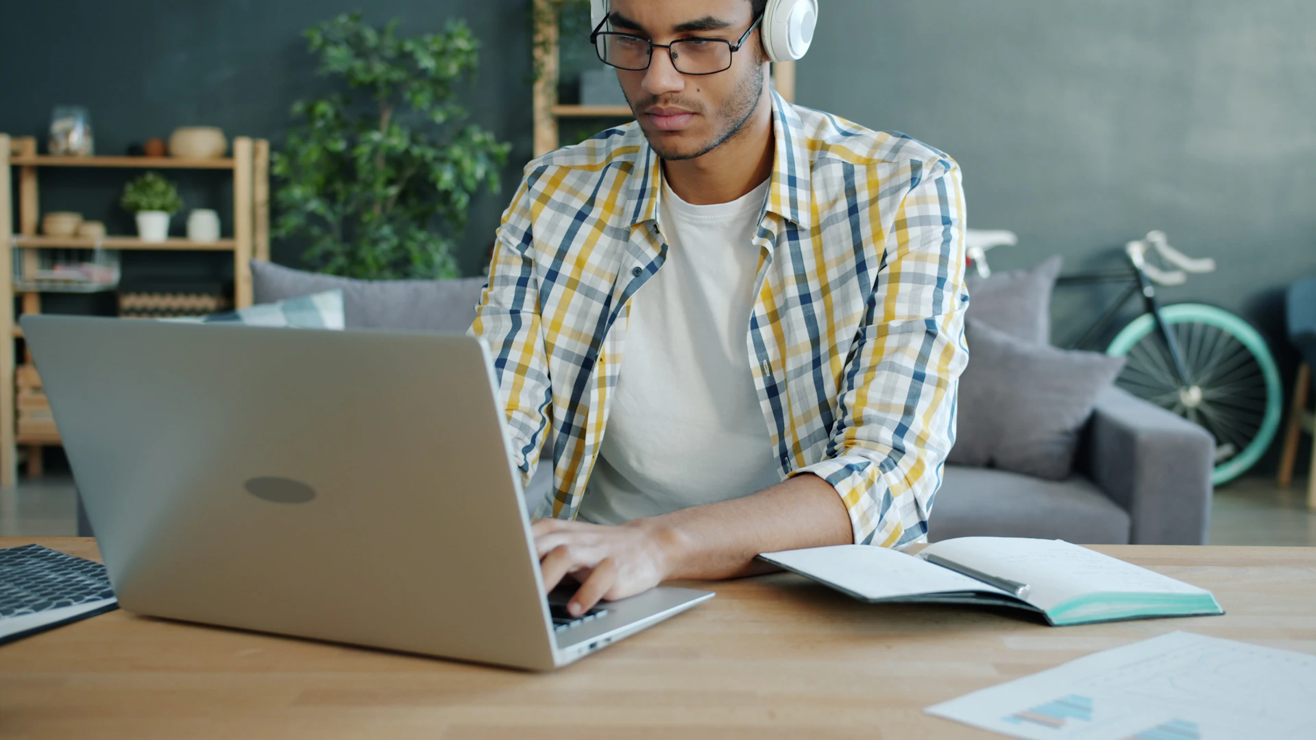 Man wearing headphones working on a laptop at a desk