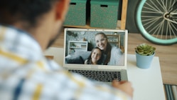Man video calls with a woman and child.