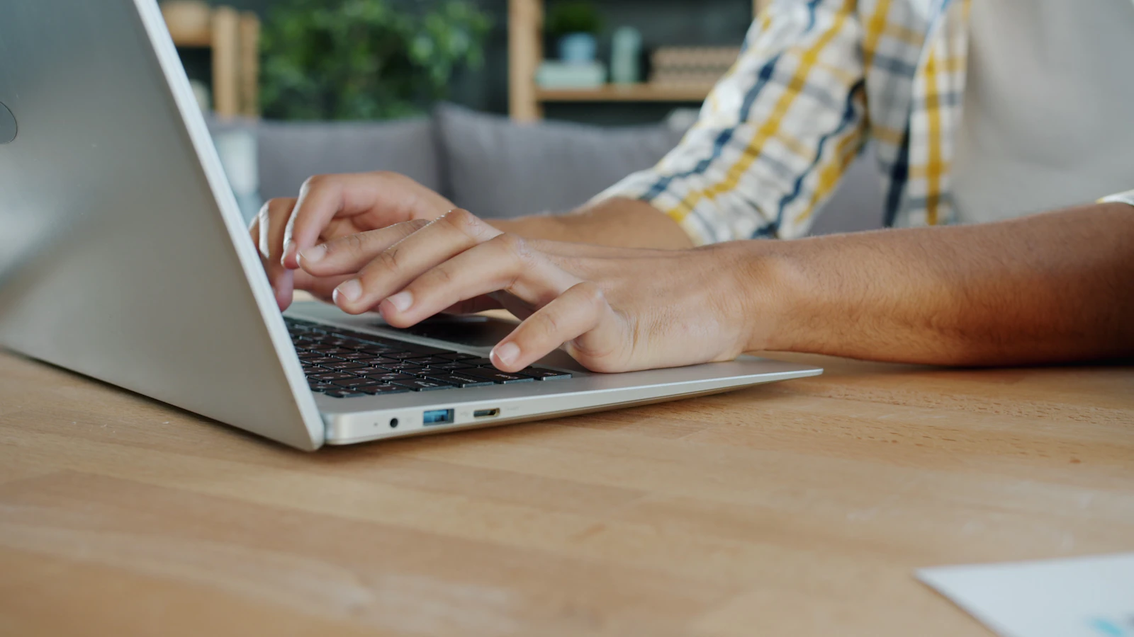 Close-up of hands typing on a laptop while preparing an IT budget
