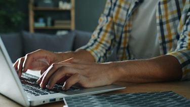 Person typing on a laptop computer indoors