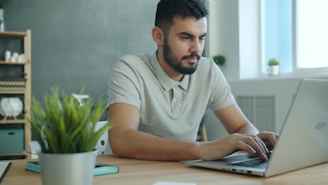 Man typing on a laptop at a desk.