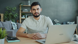 Man sitting at desk with laptop in living room