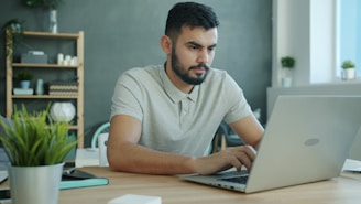 Man typing on a laptop at a desk.
