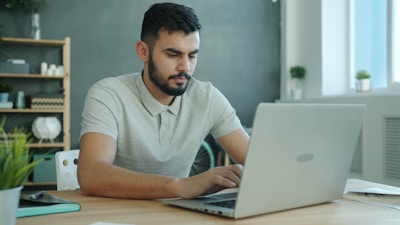 Man typing on a laptop at a desk.