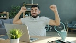 Man celebrating success while working on laptop.