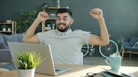 Man celebrating success while working on laptop.