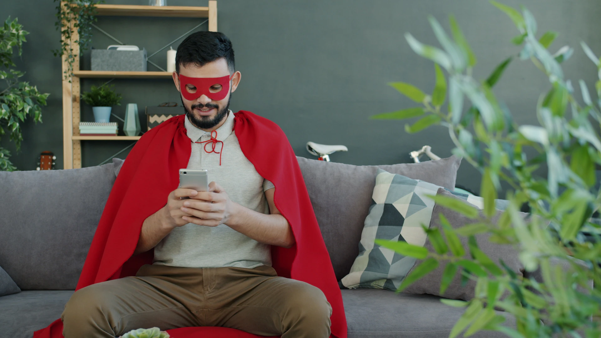 Man in superhero costume using smartphone on cell phone