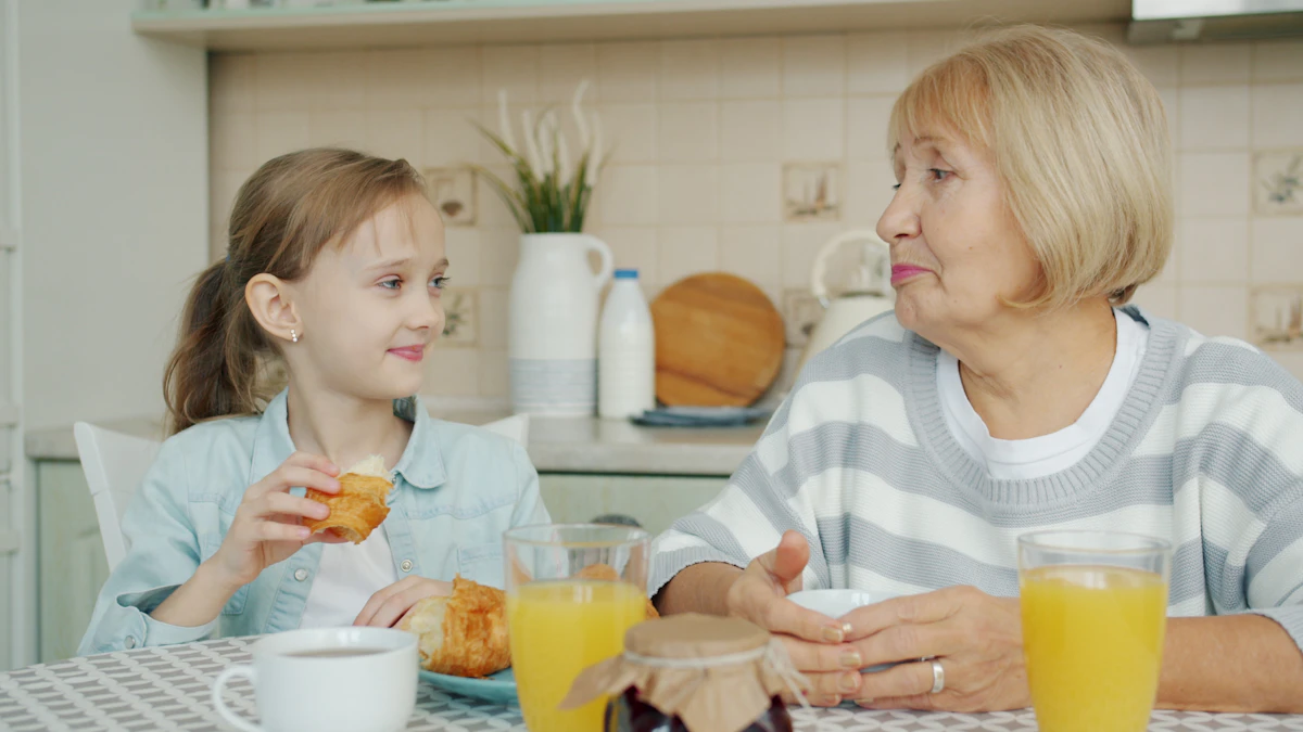 A grandmother and her adult granddaughter sharing breakfast at the kitchen table