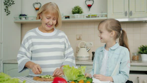Grandmother and granddaughter preparing salad in kitchen