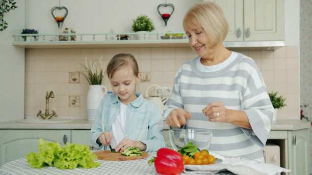 Grandmother and granddaughter preparing salad in kitchen
