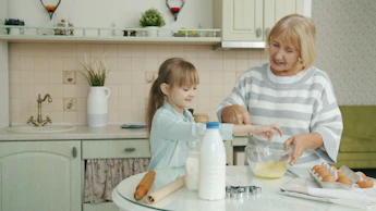 Grandmother and child baking together in a kitchen.