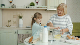 Grandmother and child baking together in a kitchen.
