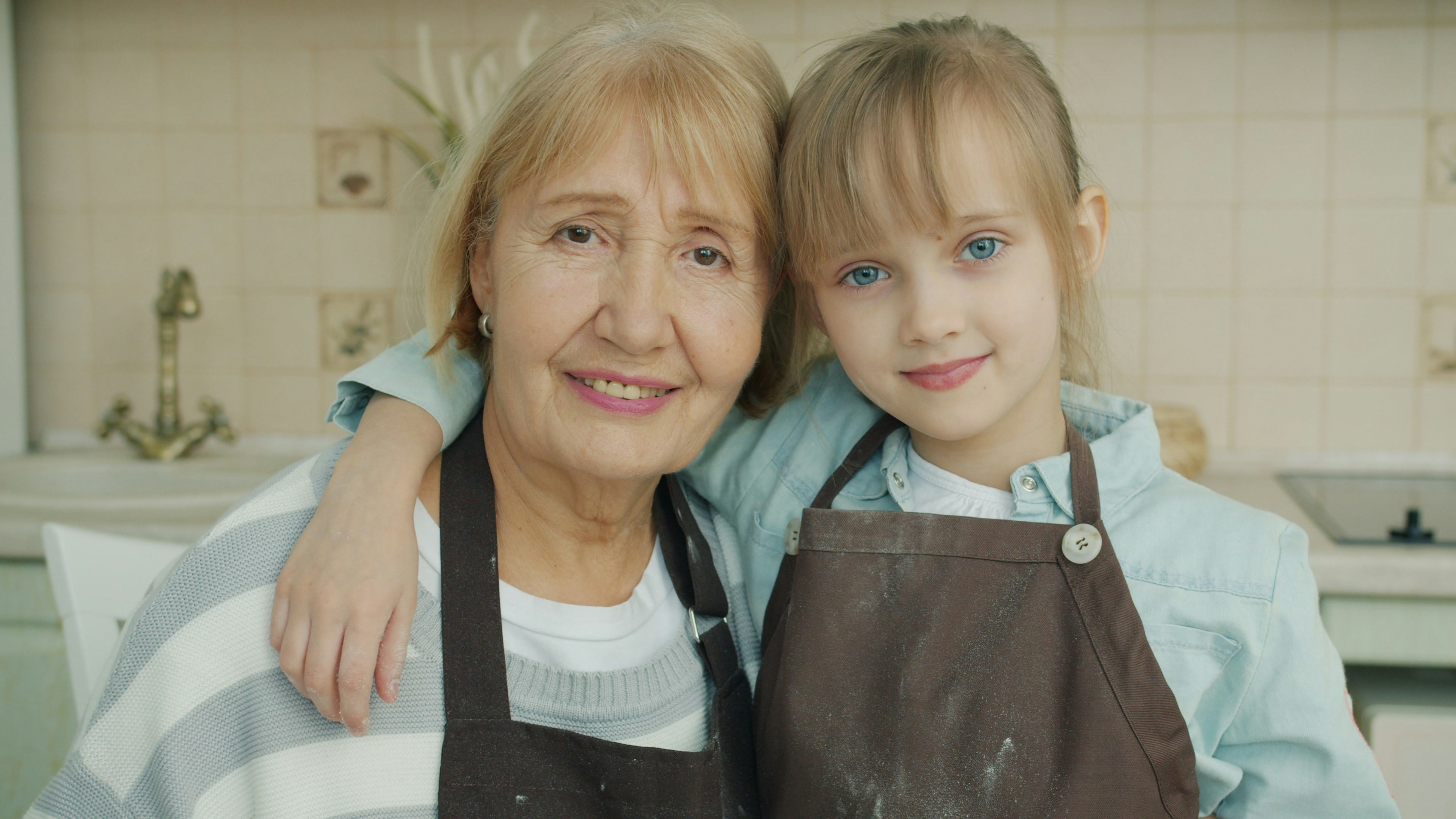 Grandmother and granddaughter smiling in kitchen