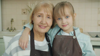 Grandmother and granddaughter smiling in kitchen