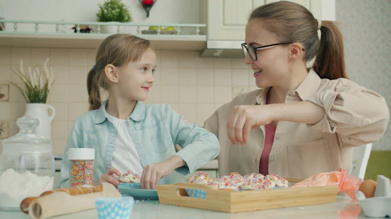 Mother and daughter decorating cookies in the kitchen