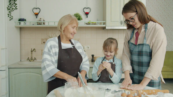 Grandmother, mother, and daughter baking together in kitchen