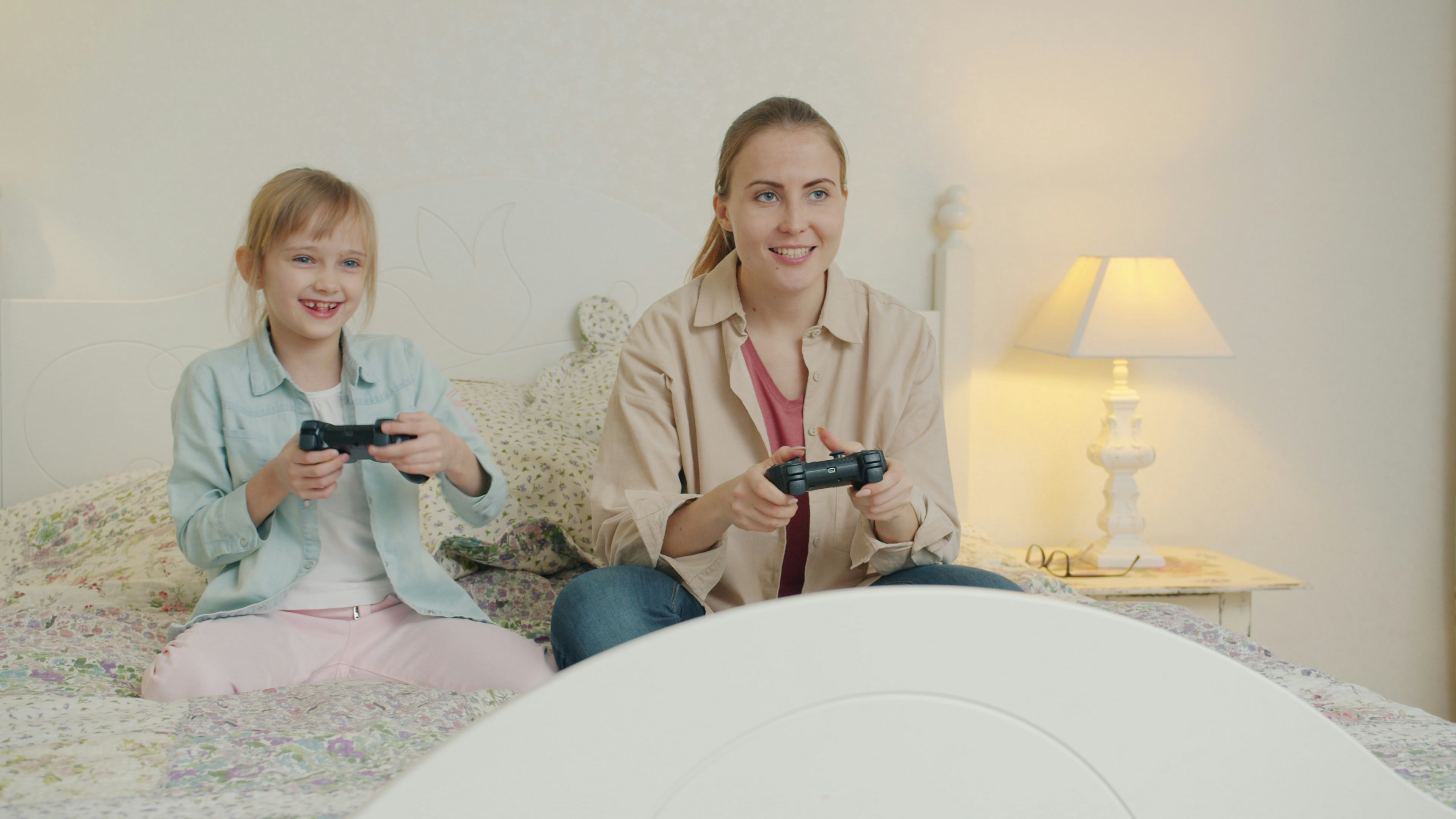 Mother and daughter playing video games together