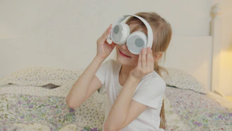 A young girl wearing large white headphones