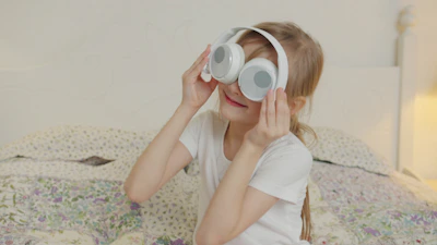 A young girl wearing large white headphones