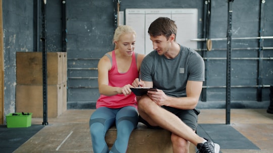 Couple looking at tablet in a gym