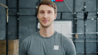 Man in gym wearing grey t-shirt looking at camera