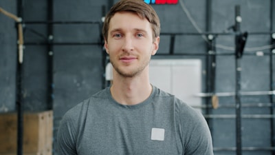 Man in gym wearing grey t-shirt looking at camera