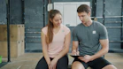 Trainer and client discussing workout plan in gym