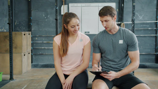 A trainer and client discussing a workout plan