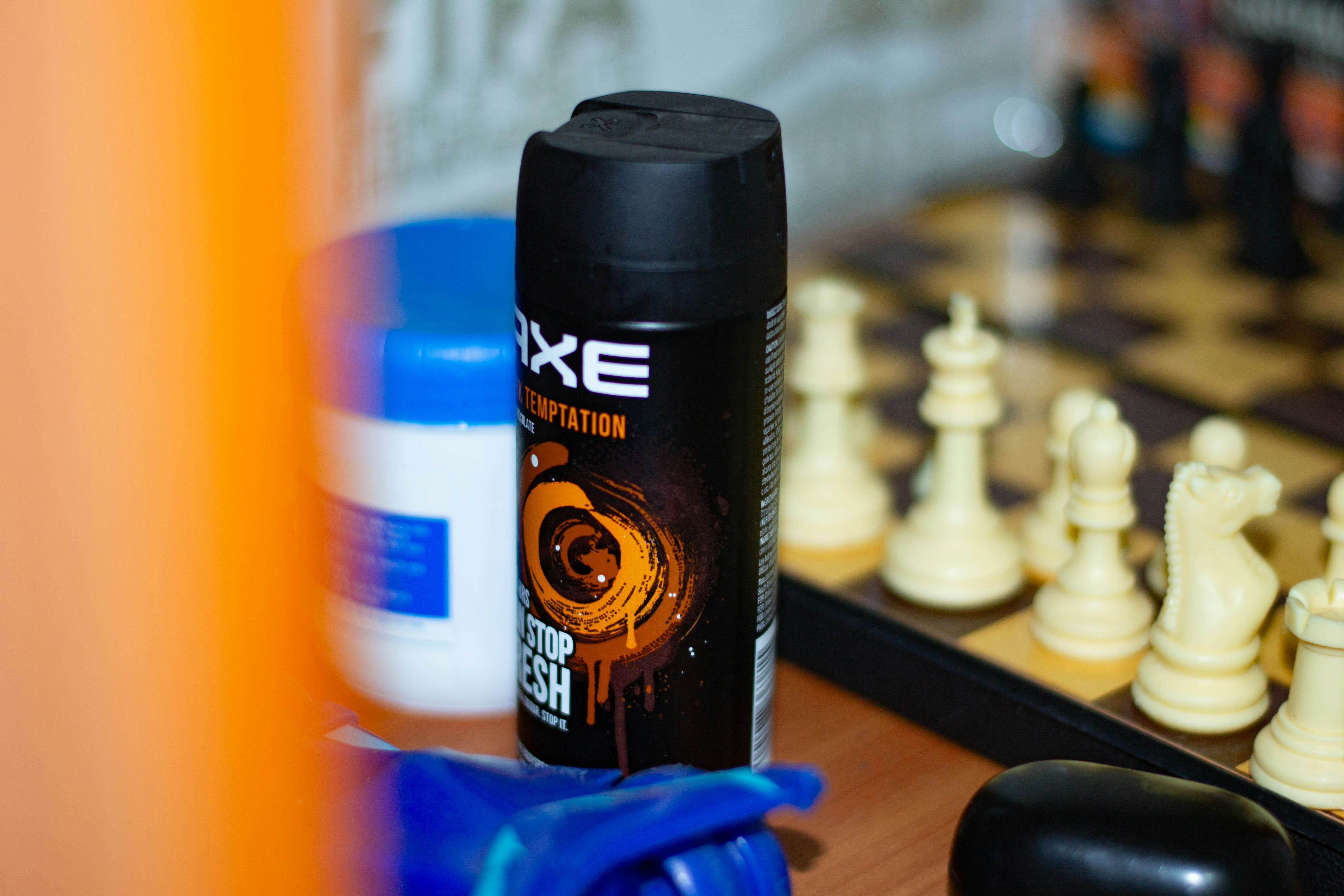 Axe body spray can next to a chessboard