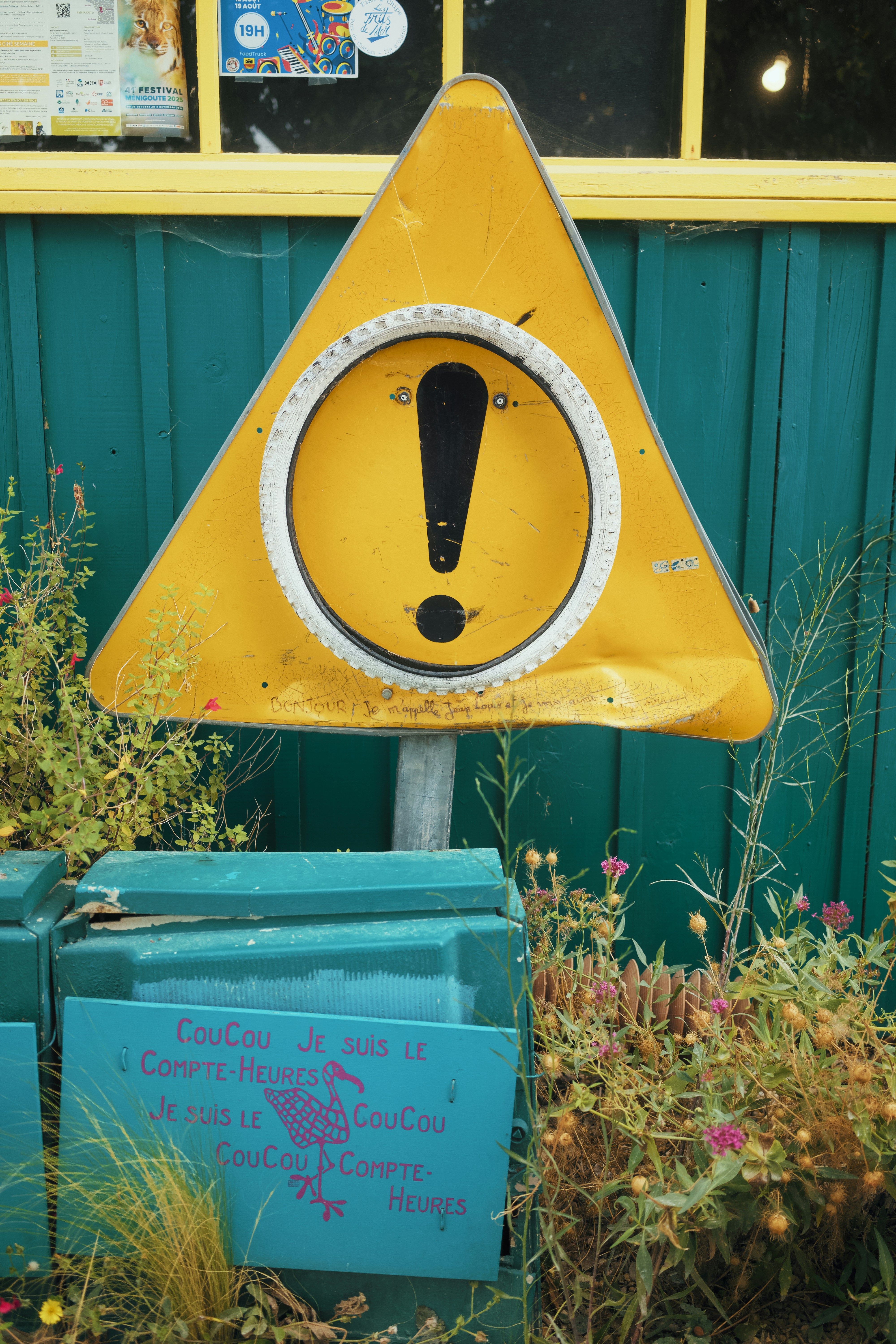 Yellow warning sign with exclamation mark outdoors.