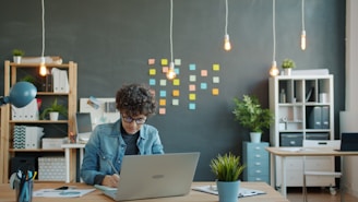 Young person working on a laptop in a modern office.