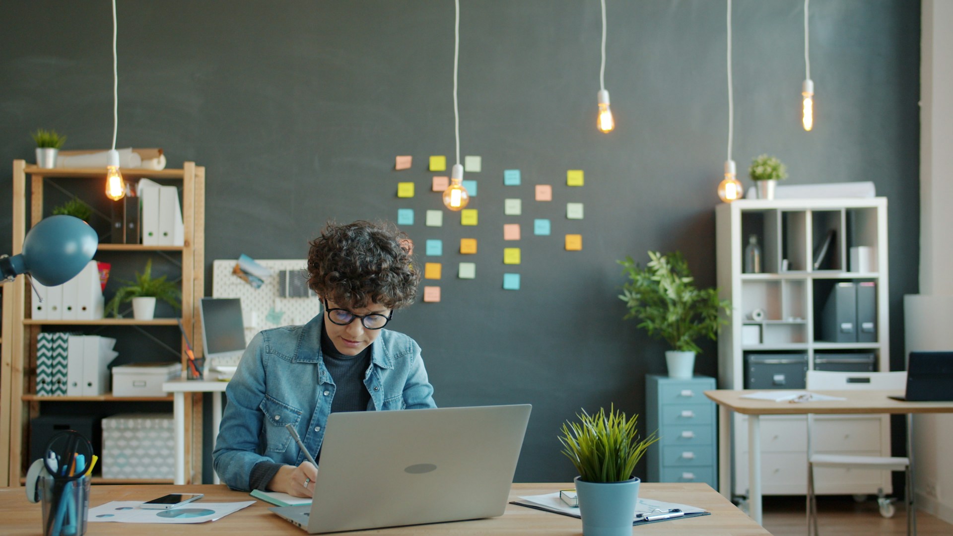 Young person working on a laptop in a modern office.