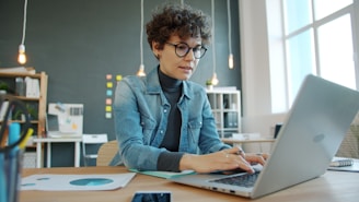 Woman working on a laptop in a modern office.